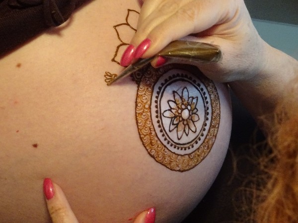 Henna Art Schweiz beim bemalen eines Baby Bauchs