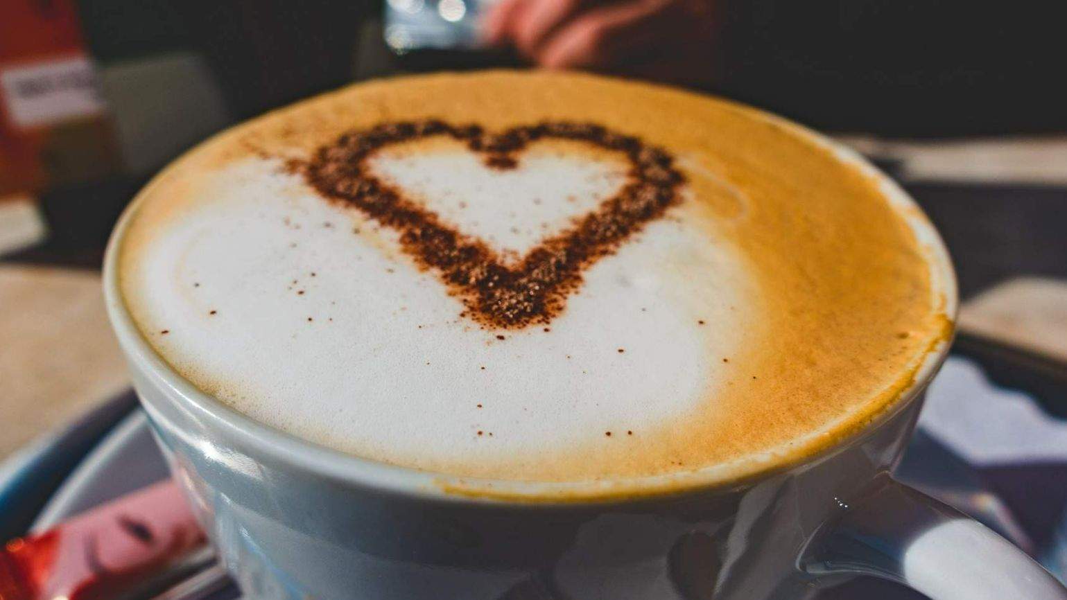 Kaffeetasse mit Herz aus Schoggipulver im Milchschaum