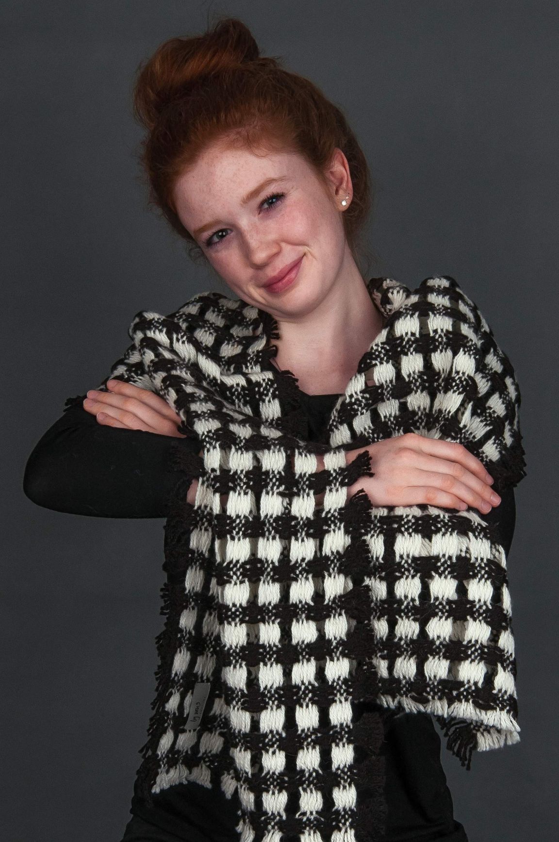 rothaarige junge Frau trägt schwarz-weiss karierten Alpaka Schal