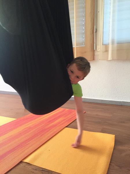 A child in a yoga swing during Flying Kids Yoga at Mii-Ruum Studio Lucerne.