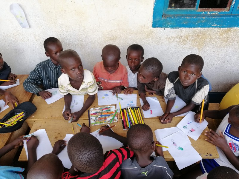 Afrikanische Kinder aus Kenia sitzen in der Schule und zeichnen