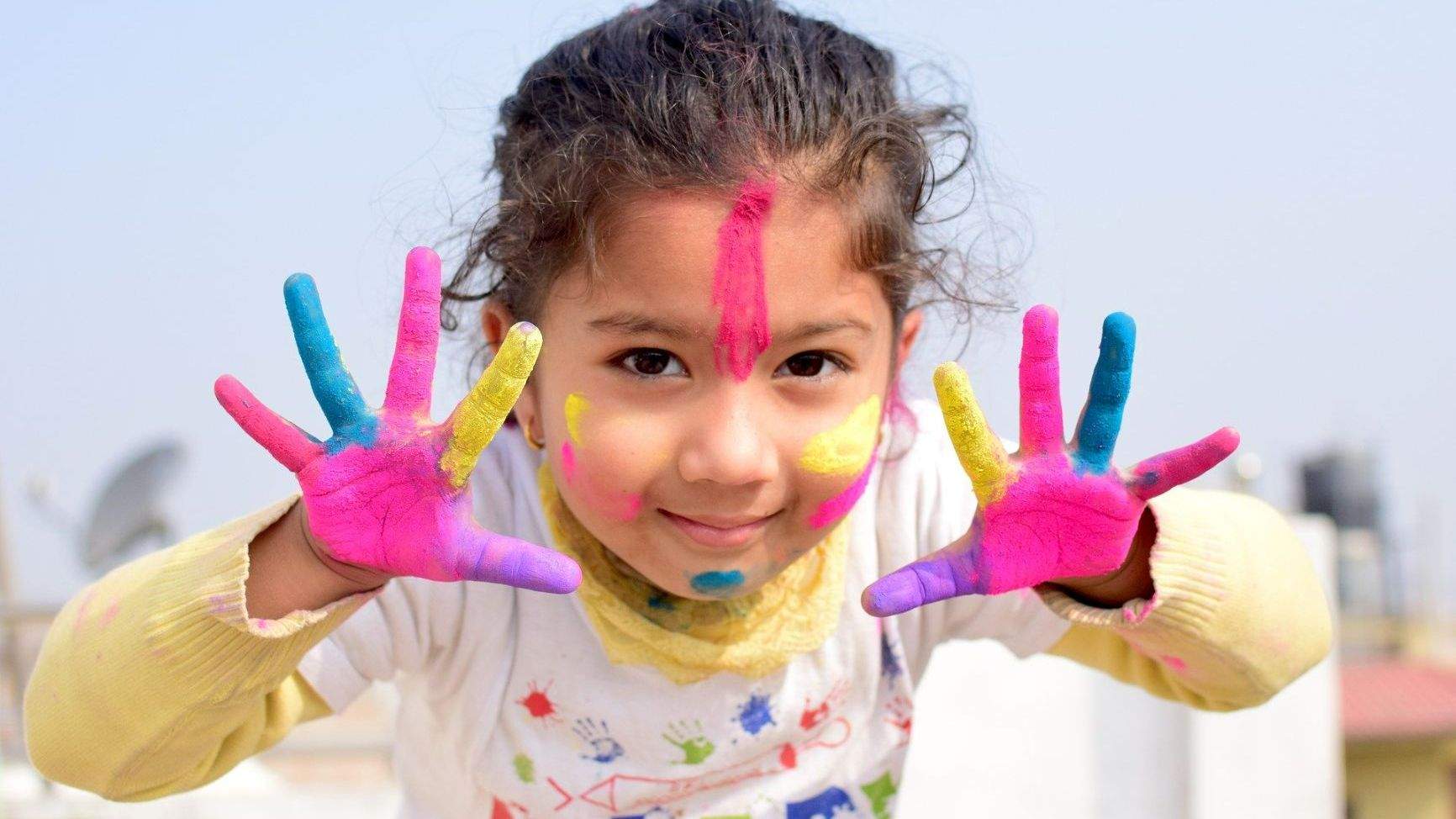 Kind mit farbigen Händenn und Gesicht