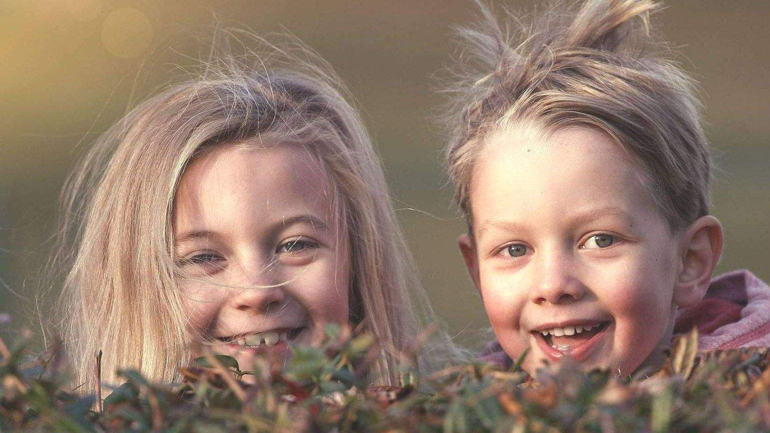 Zwei Kinder hinter gras