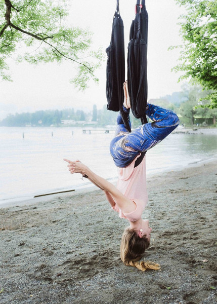 Lara Bühler in her yoga swing outside near by the lake in Lucerne.