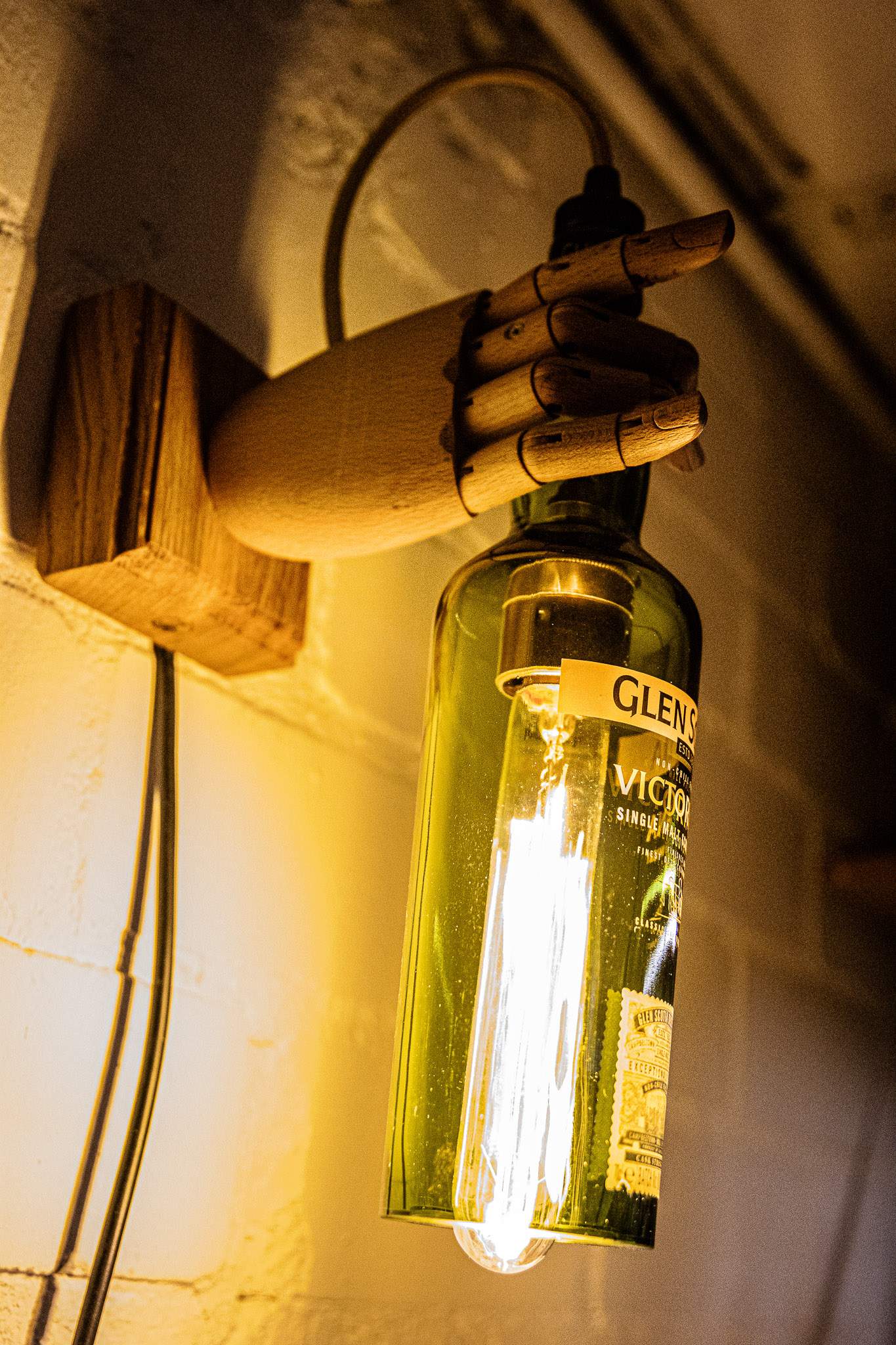 Upcycling Flasche gehalten von Holzhand montiert auf edlem Eichensockel. CHF 370.00