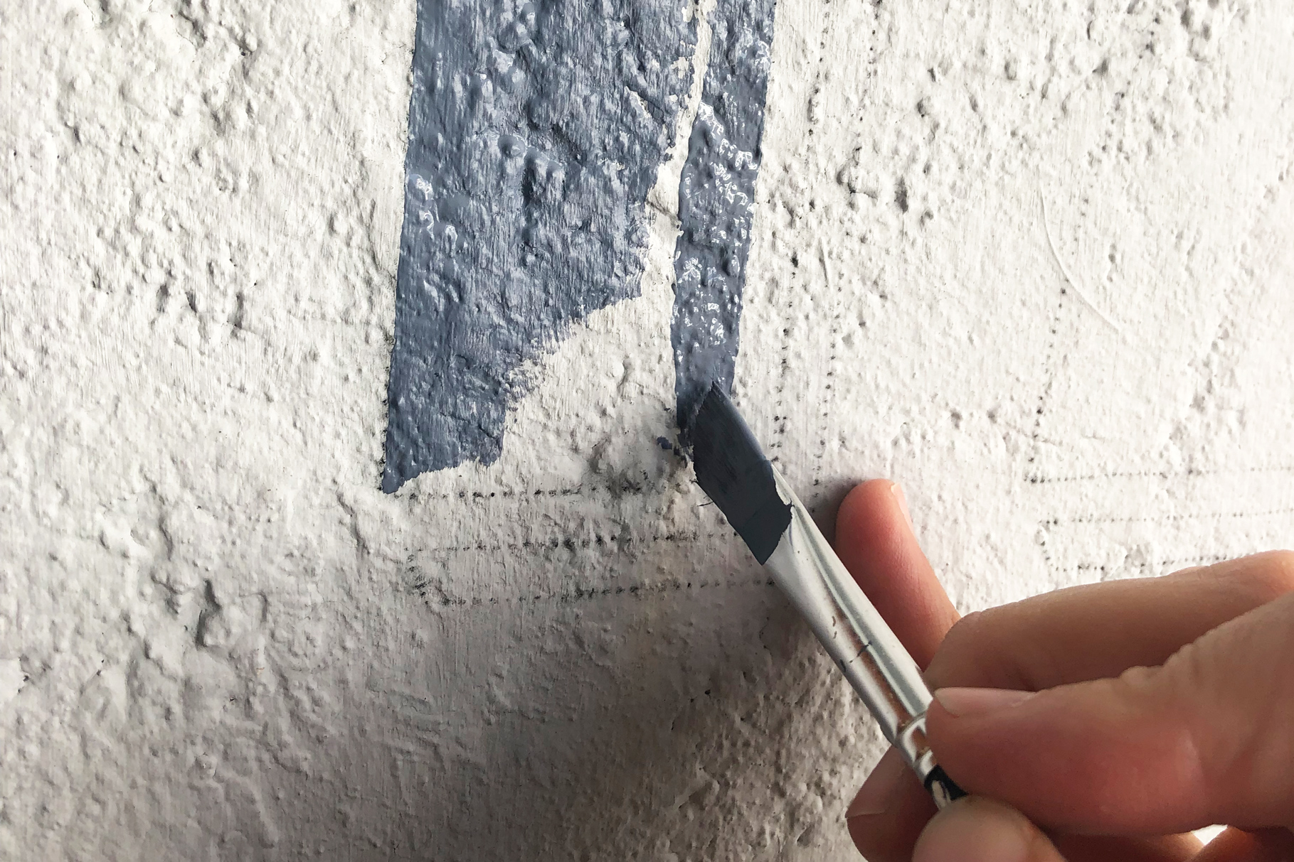 Traditionelle Schriftenmalerei wird von Hand auf Fassade gemalt