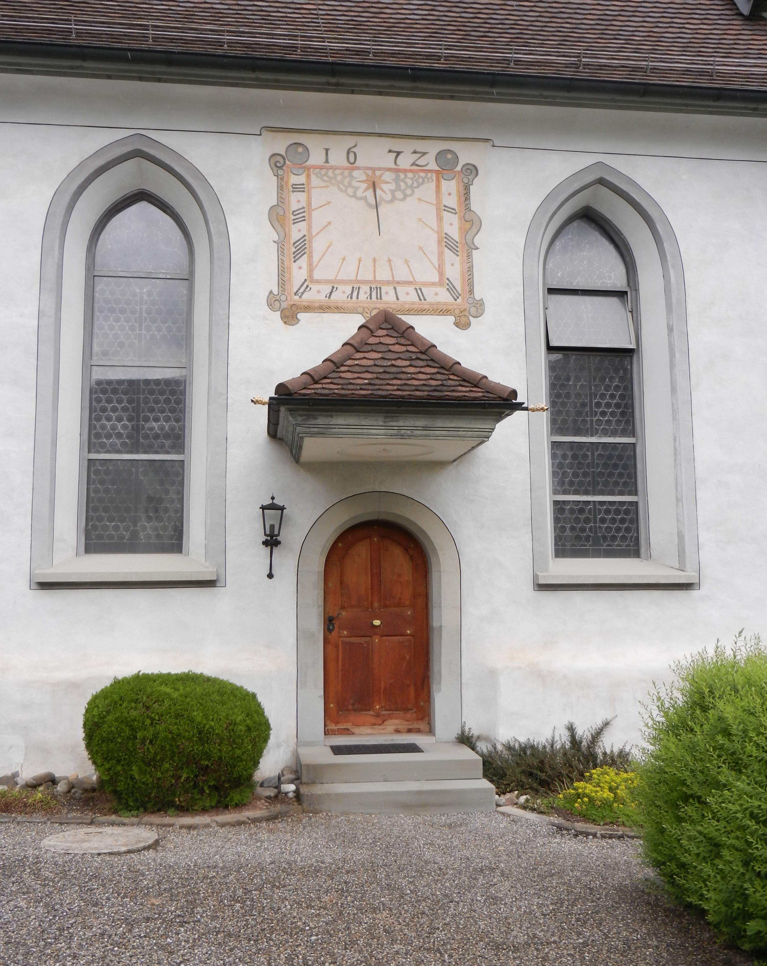 Seiten-Eingang der Pfarrkirche mit Sonnen-Uhr