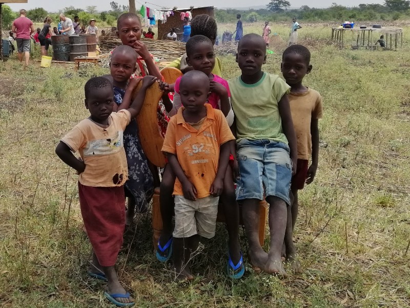 Kinder einer Familie in Kenia warten auf die Fertigstellung der Lehmhütte