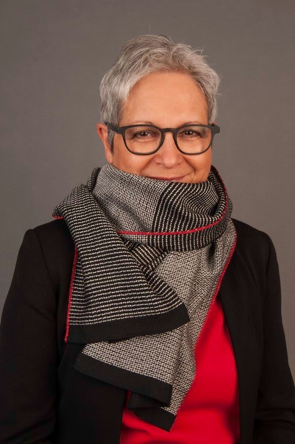 elegante, ältere Frau trägt schwarz-weissen Schal mit zwei verschiedenen Mustern und rotem Akzentrand