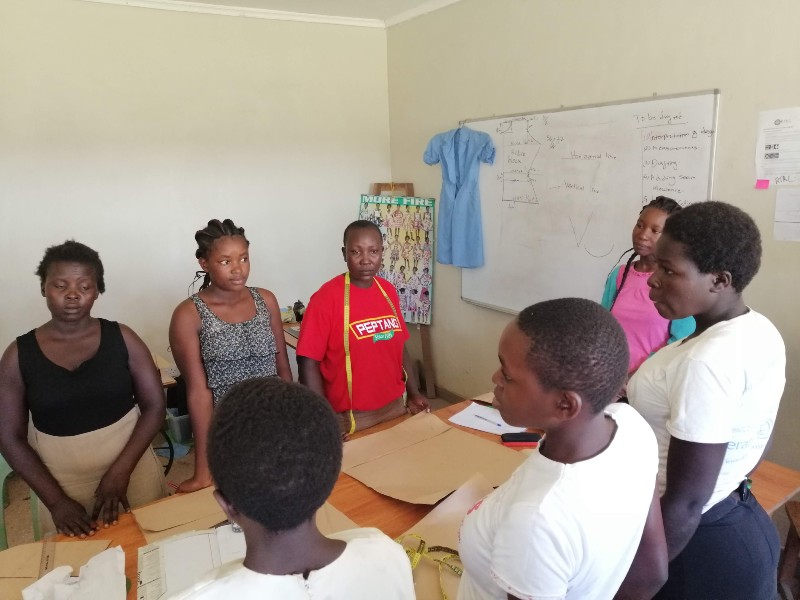 Angehende Schneiderinnen hören ihrer Lehrerin zu und absolvieren eine Berufslehre in Kenia