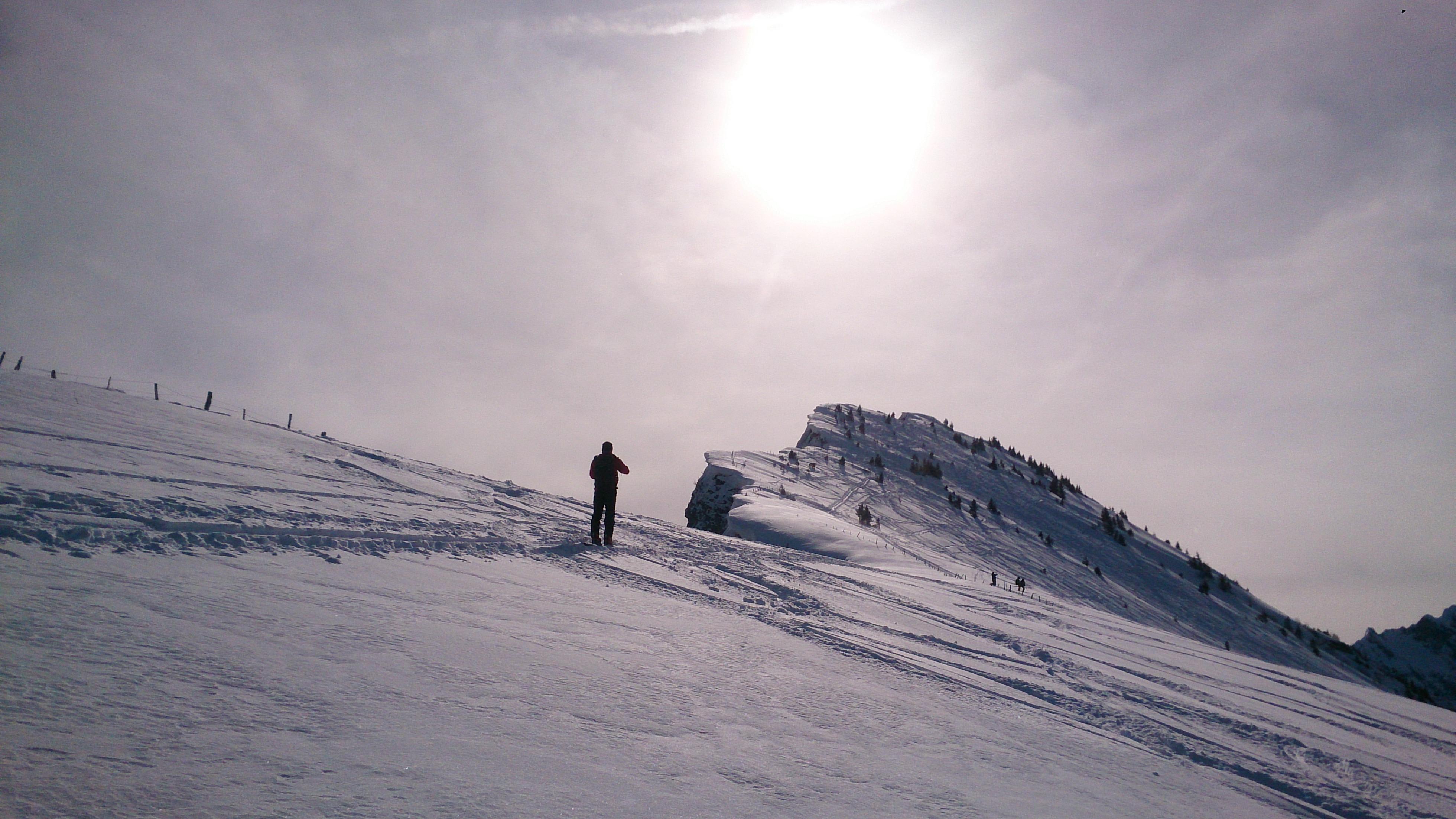 Skitourenspur auf einer Skitour mit Gipfel im Hintergrund und strahlend blauem Himmel