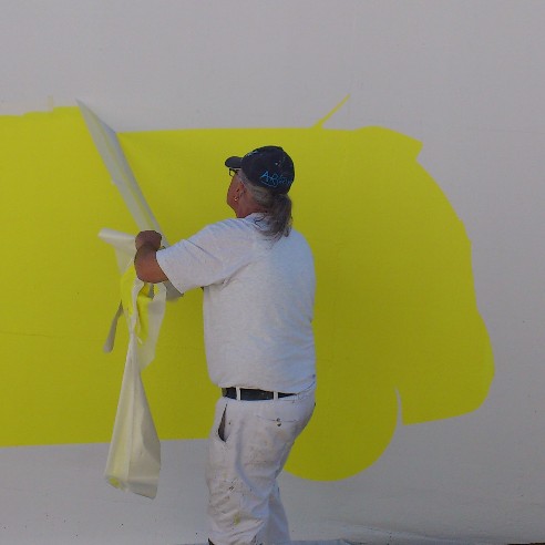 Malermeister Cotti entfernt die Abklebung eines Piktogramms