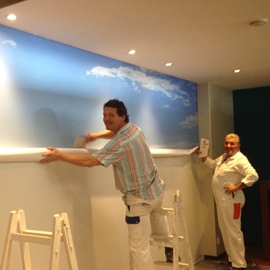 Das Maler Cotti-Team zieht eine 5 Meter lange Fototapete auf
