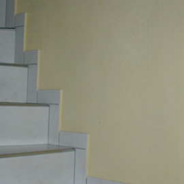 Spachteln bestehender weisser Wandfläche, Resultat: exklusiv und individuell wirkendes Treppenhaus