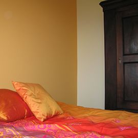 Wände in verschieden farbigen Orangetönen streichen mit Ziel eines warm wirkenden Schlafzimmers