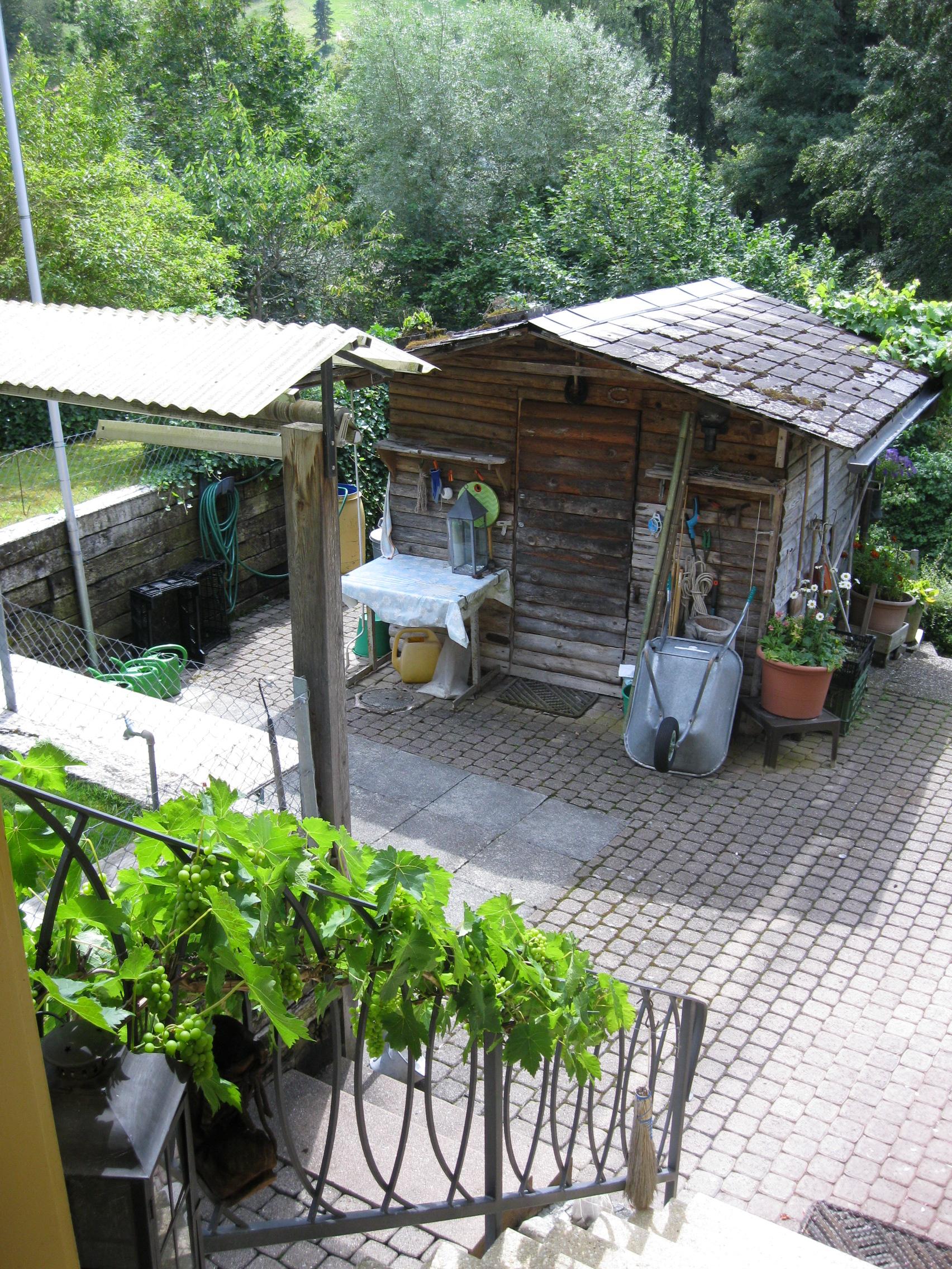 Gartensitzplatz und Gartenhäuschen für Gartenuntensilien oder Gartenmöbel.