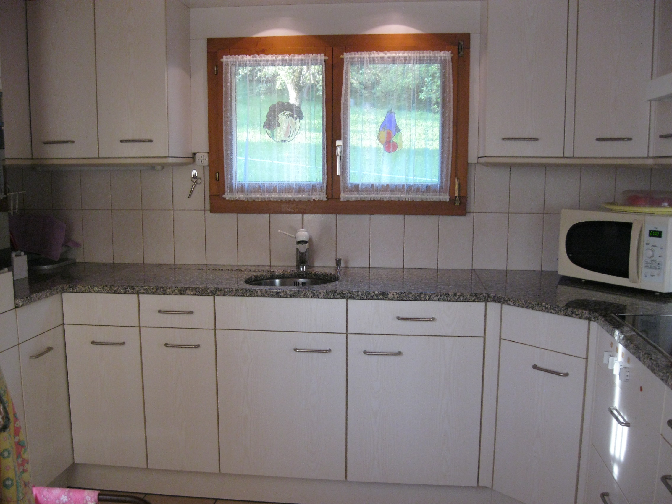 Küche mit Granitabdeckung, Glaskeramik, Dampfabzug, Abwaschmaschine, grosser Kühlschrank.
